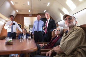 Alan Gross with his wife Judy, attorney Scott Gilbert, Rep. Chris Van Hollen, D-Md., Sen. Patrick Leahy, D-Vt., and Sen. Jeff Flake, R-Ariz. watch television on board a U.S. government plane headed back to the U.S. as the news breaks of his release, Dec. 17, 2014. (Official White House Photo by Lawrence Jackson)