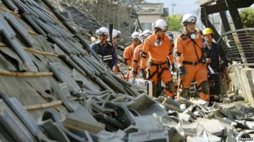 Firefighters walk among collapsed houses caused by an earthquake in Mashiki town, Kumamoto prefecture, southern Japan, in this photo taken by Kyodo, April 15, 2016. (Reuters Open)