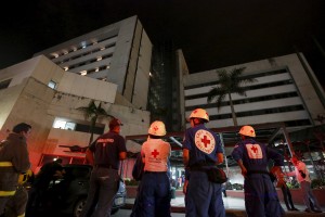 Rescue team members wait outside a clinic that was evacuated after tremors were felt resulting from an earthquake in Ecuador, in Cali, Colombia, April 16, 2016. REUTERS/Jaime Saldarriaga